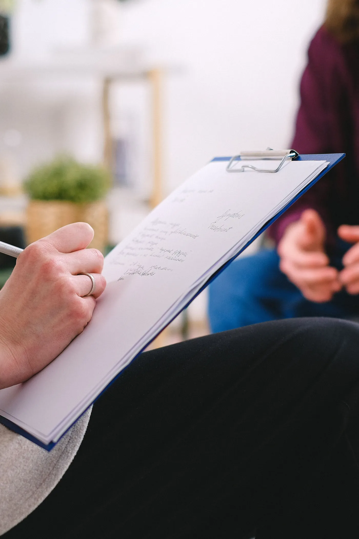 Clinician taking notes during a consultation