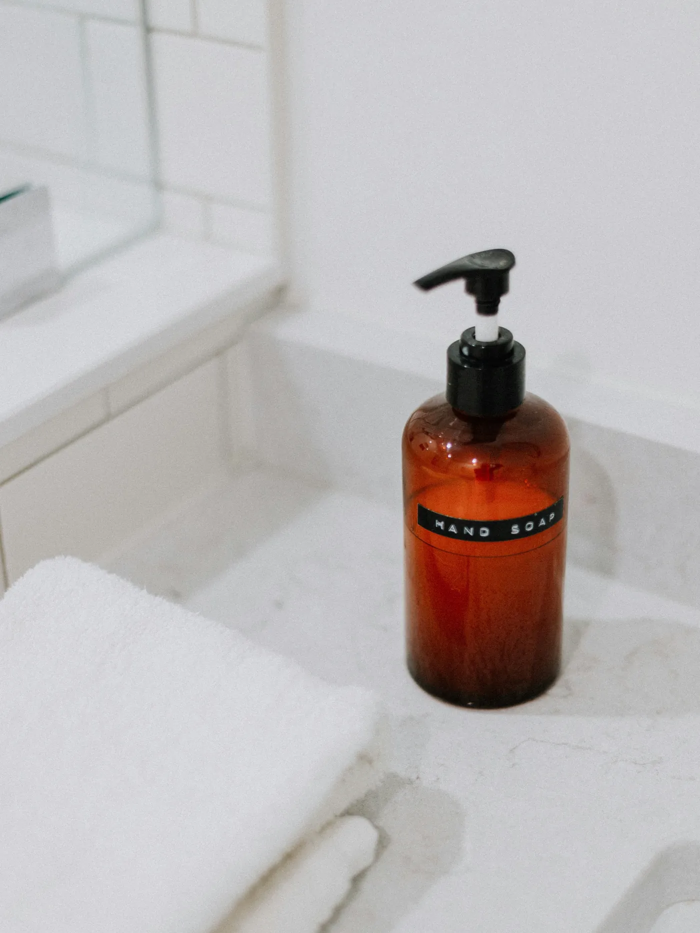 Clean folded towels and a pump bottle on a bright counter